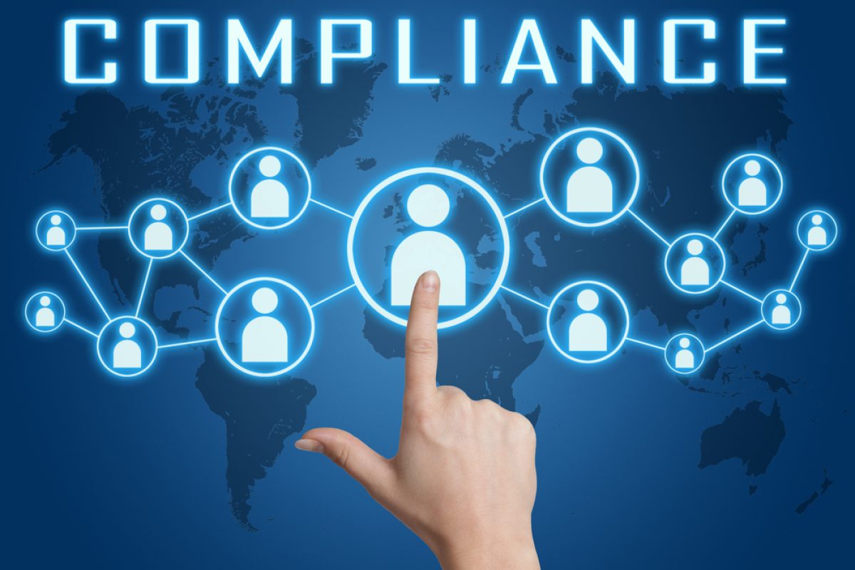 Compliance concept with hand pressing social icons on blue world map background.